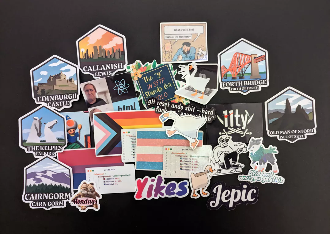 Bunch of assorted stickers including development, scottish destinations and silly stickers on a black background